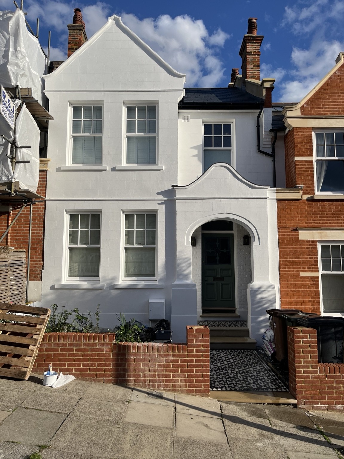White painted period house with decorative gable and arched entrance